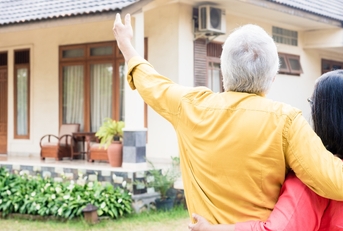 elderly man pointing to a house