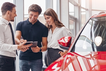 signing papers in card dealership