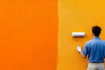 a person painting a vibrant orange wall