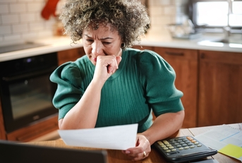 woman reviews paperwork at her kitchen