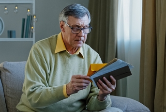 Caucasian man checking sorting letters in living room