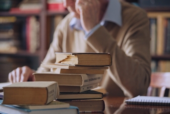 senior historian reading literature at the library