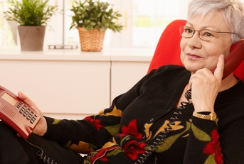 Pensioner woman using landline phone