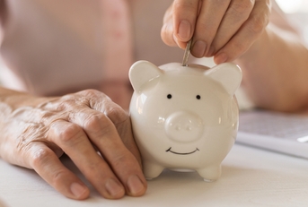 putting money coins in a piggy bank