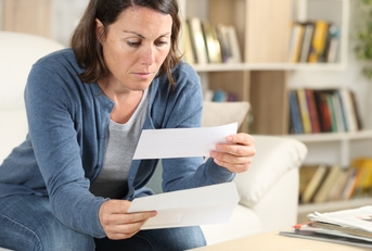adult woman looking receipts at home