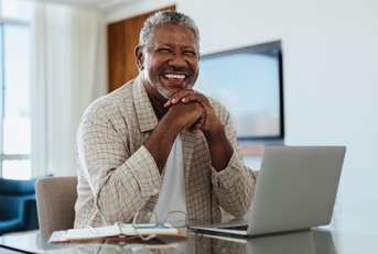 senior man working on laptop at home office