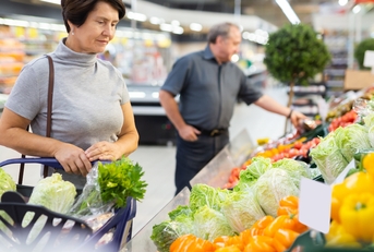 female customer selects savoy cabbage