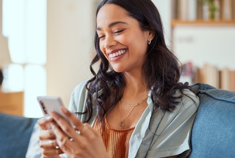 Woman smiling while using smartphone