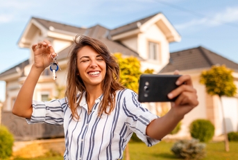 Woman taking a selfie with her new house keys