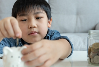 children putting coin for saving