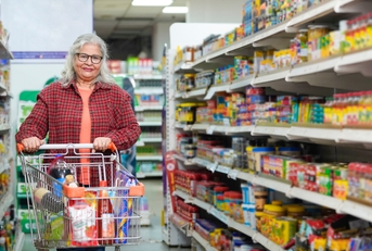 senior woman purchasing at grocery shop