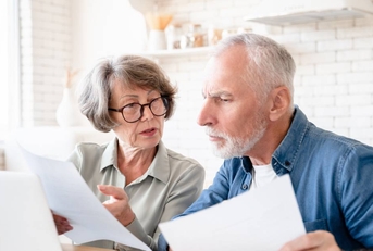Concerned senior couple doing paperwork