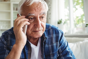 tensed senior man talking on mobile phone 