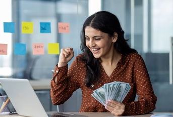 happy young businesswoman holding money