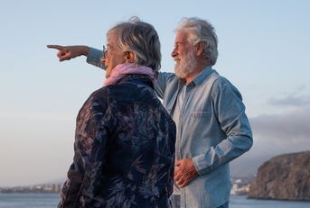 senior couple standing at sunset