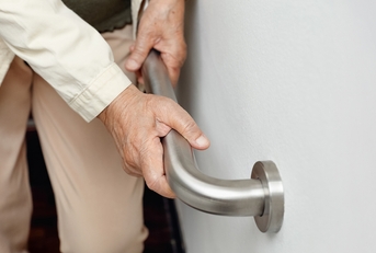 elderly woman holding handrail