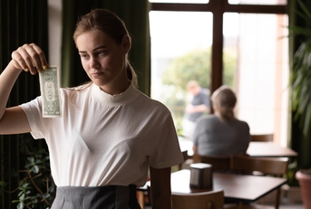 sad waiter in restaurant with tips