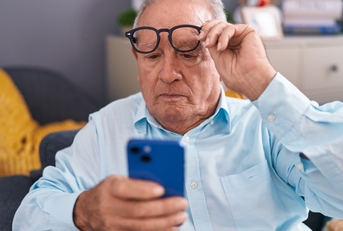 man looking at smartphone screen with vision problem