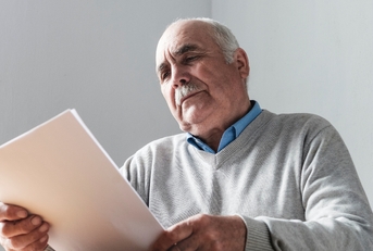 senior man reading a paper document
