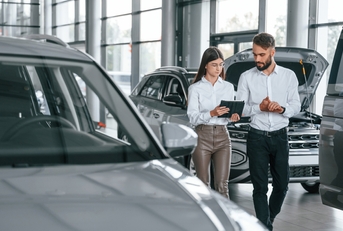 man with woman in the car dealership together
