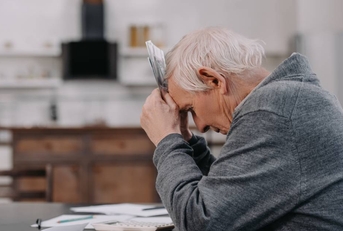 Stressed senior man sitting at table