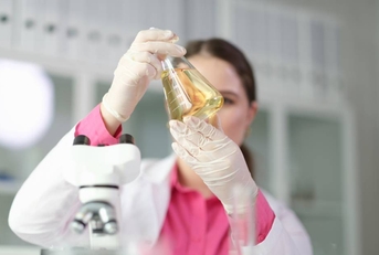 Chemist looking at flask