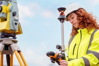 Red head woman in yellow jacket uniform working with mapping and surveying