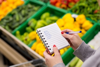 woman with notebook in grocery store
