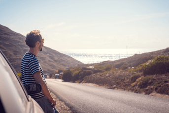 person leaning against car by side of road