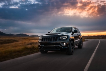 2022 Jeep Grand Cherokee drives on the road at sunset