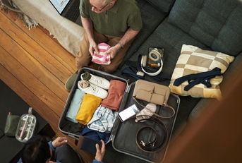 couple diligently packing suitcase
