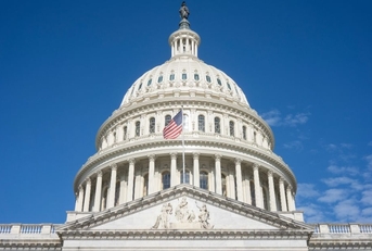 The United States Capitol dome against a clearing blue sky viewed from the east front of the U.S. Capitol building in Washington, DC.