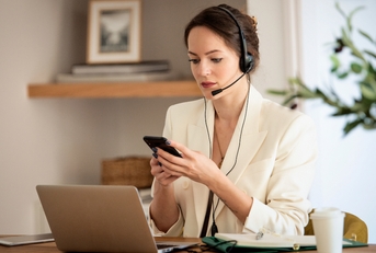 businessswoman wearing headset and using smartphone