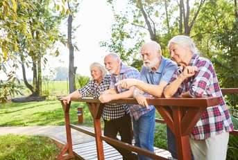 senior group is standing on a small bridge