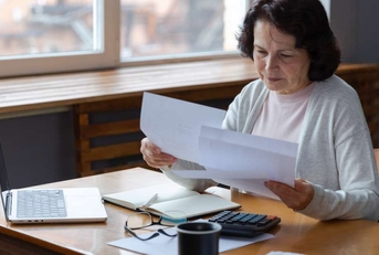 woman sit with laptop and paper document