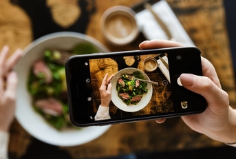 food critic using smartphone to take a photo of their meal
