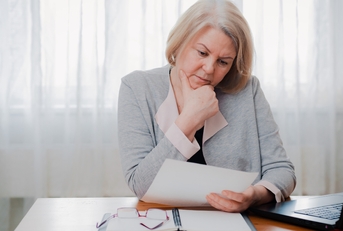 senior woman reading paper documents