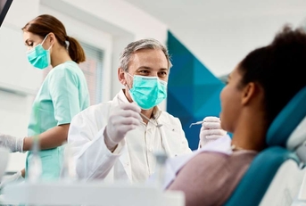 smiling dentist with face mask