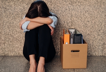 woman hiding her face after being laid off from job