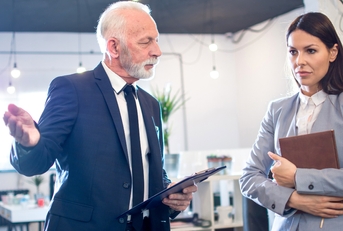 senior man boss talking to female employee