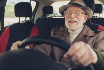 grey-haired man driving car