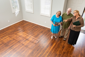 real estate agent showing to senior couple a new home