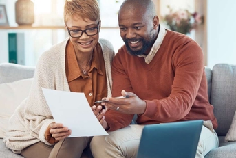 couple on sofa check bank account