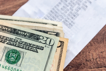 A stack of US Dollar bills on a table