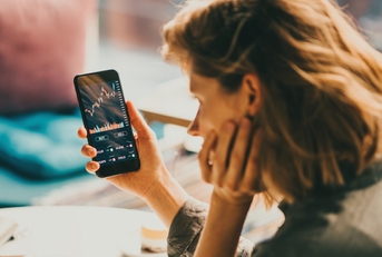 woman using mobile phone investing 