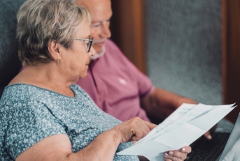 senior couple at home paying bills