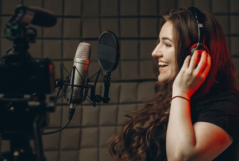 Woman recording voice in studio