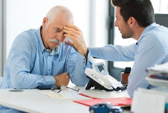 sad worker and younger one talking in office
