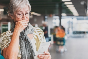 senior woman checks her grocery receipt