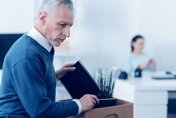 boomer aged man cleaning out desk